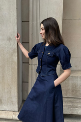 a lady in a jean jacket and a jean skirt